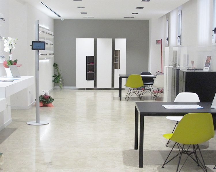 negozio-occhiali-con-stelo-Ipad-Ottica-Da-Ros-a-Conegliano-Veneto-interno foto a colori degli interni del negozio di vendita occhiali e controllo della vista Ottica Da Ros, mobili e pareti bianche sedie colorate con stelo iPad